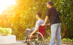 Patient in a wheelchair and his caregiver